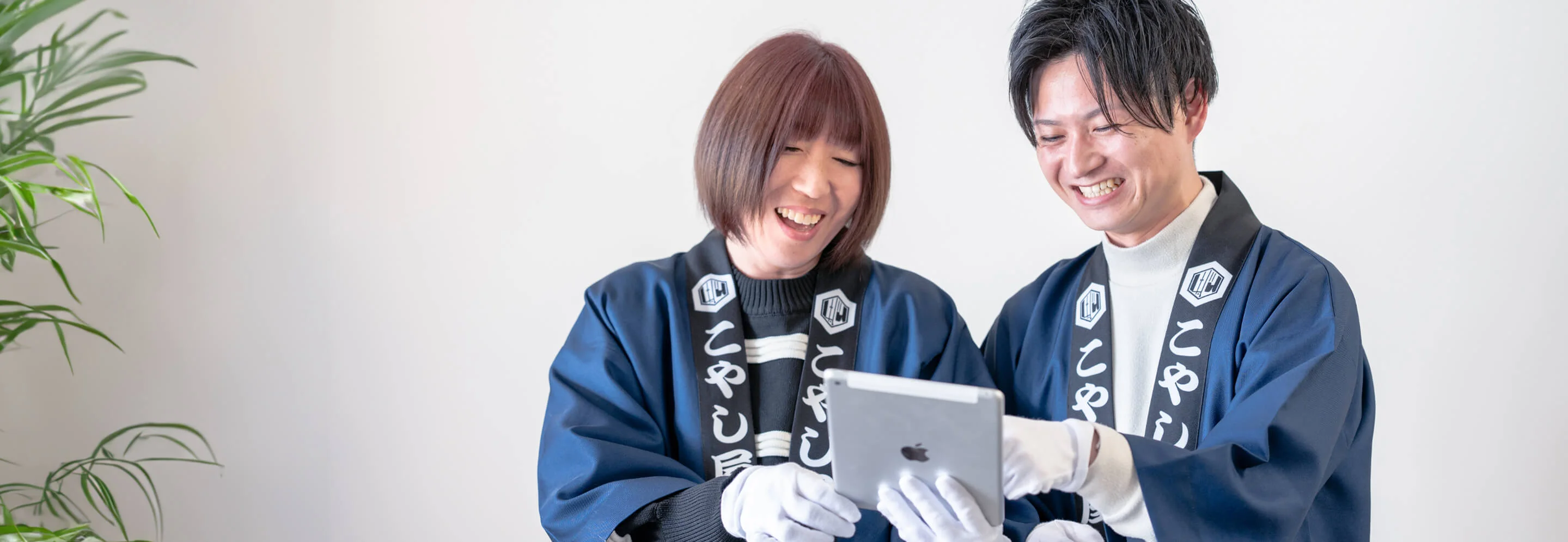 笑顔でタブレットを見るこやし屋つくば並木店のスタッフ